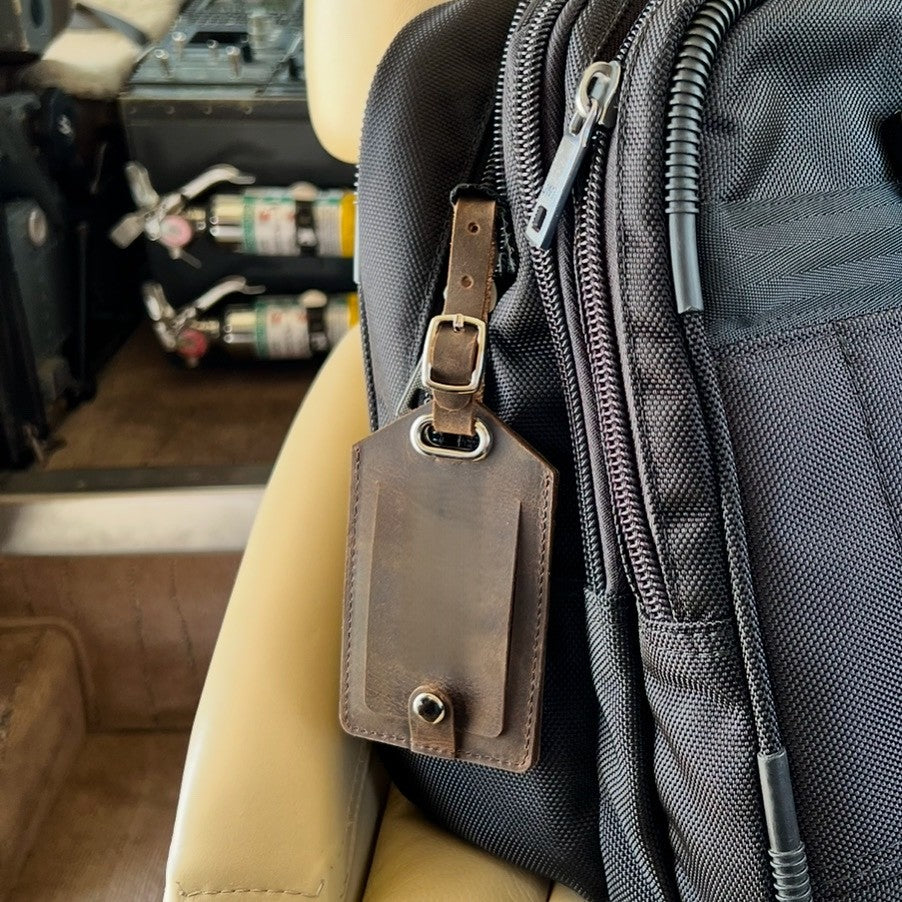 Leather AirTag luggage tag attached to flight bag 