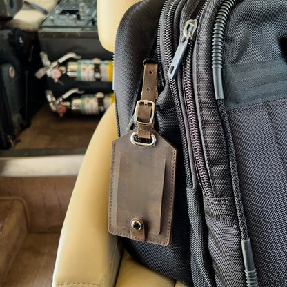 Leather AirTag luggage tag attached to flight bag 