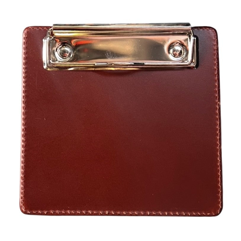 Leather pilot clipboard holding flight paperwork and checklist