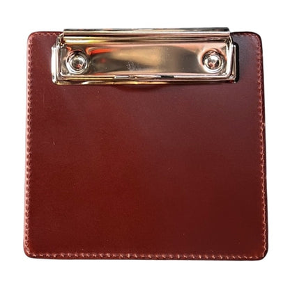 Leather pilot clipboard holding flight paperwork and checklist